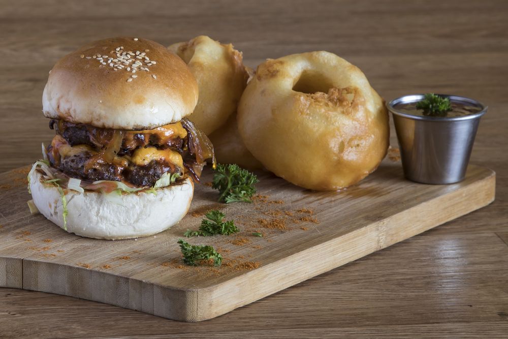 Double bacon and cheese burger on wooden plate Double bacon and cheese burger on wooden plate