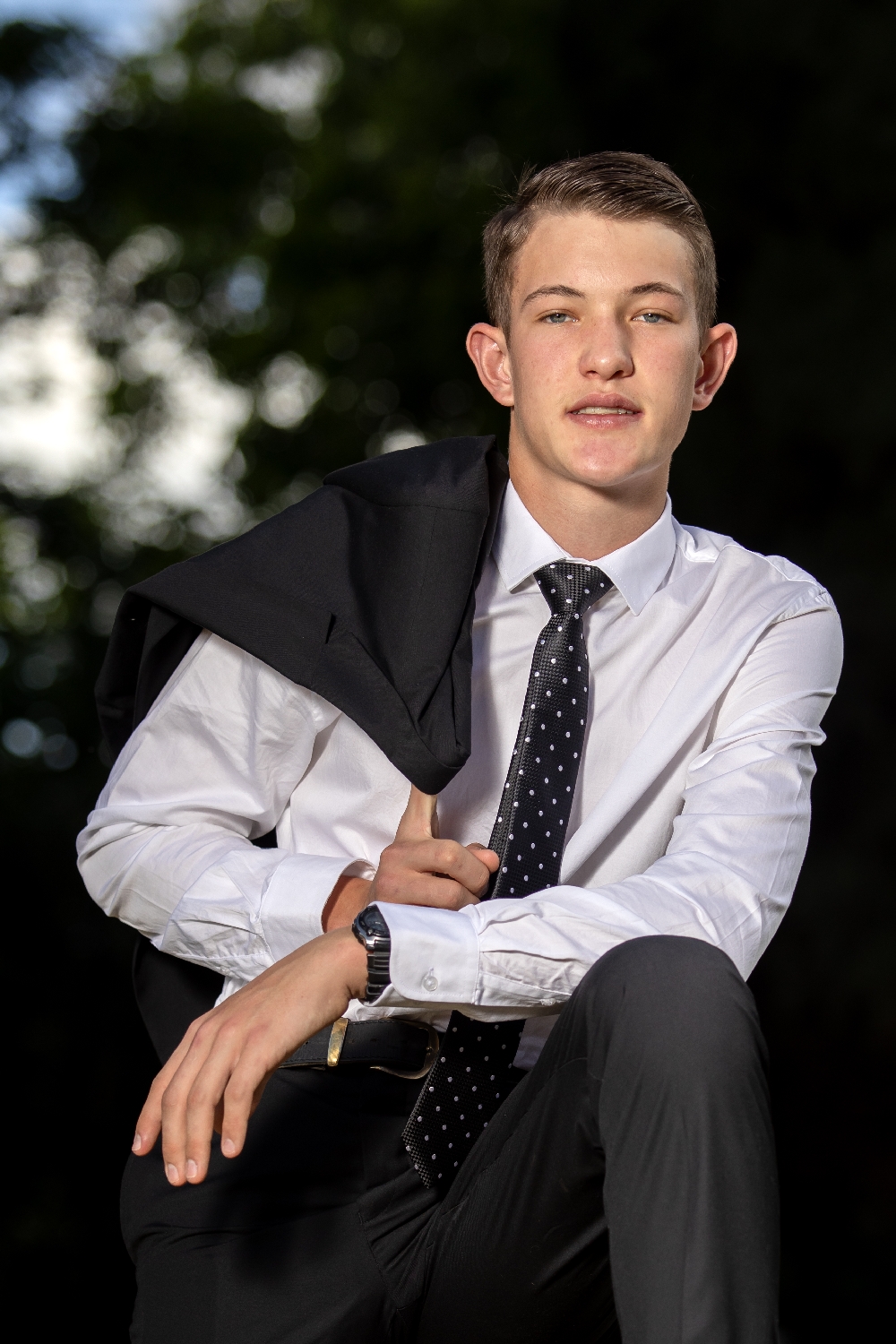 Matric farewell young man standing with jacket over shoulder