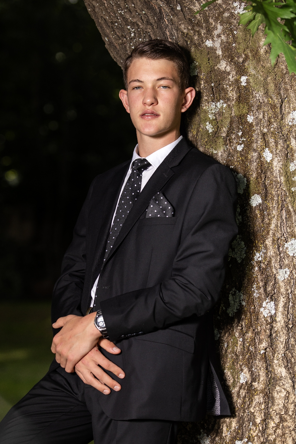 Young man leaning against an oak tree _ portrait